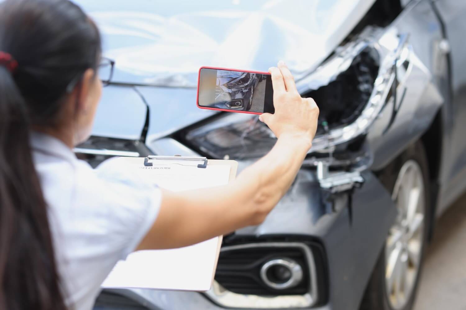 agente-de-seguros-de-mulher-tirando-fotos-de-um-carro-quebrado-em-close-up-do-telefone-celular-estimando-o-custo-de
